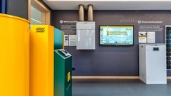 Ein moderner Raum mit einem gelben Tank, einem weißen Heizgerät und einem Solarpanel an der Wand, das innovative Technologien präsentiert.