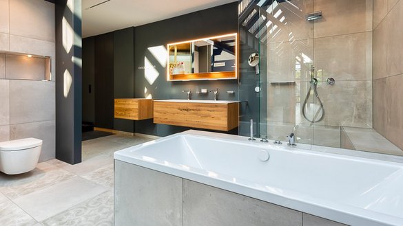 Ein modernes Badezimmer mit einer freistehenden Badewanne, eleganten Holzschränken und einer großen, gläsernen Dusche.